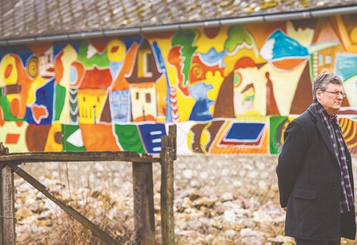 <h1>Andor László egy freskóval díszített ház előtt (Németh András Péter felvétele)</h1>-