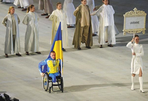 <h1>A kerekes székben ülő ukrán fiatalember a nemzeti zászlóval a kezében a szocsi paralimpián részt vevő ukrán küldöttséget képviselte a pénteki megnyitón, amelyen jelen volt Putyin orosz elnök is. Az orosz–ukrán konfliktus alaposan rányomta bélyegét a paralimpiai játékokra. Az ukrán versenyzők sokáig töprengtek azon, hogy bojkottálják-e a megnyitót, ez azonban a kizárásukkal járt volna. Úgy döntöttek, csak egy versenyző lesz ott az ukrán zászlóval. Közben egyre inkább úgy tűnik: új hidegháború felé tart a világ. (Fotó: Profimedia-Red-Dot)</h1>-